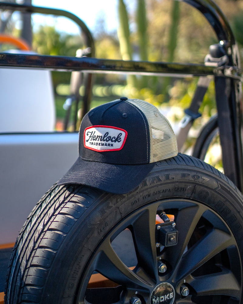 Hemlock Remington Trucker Hat in Black on top of spare tire