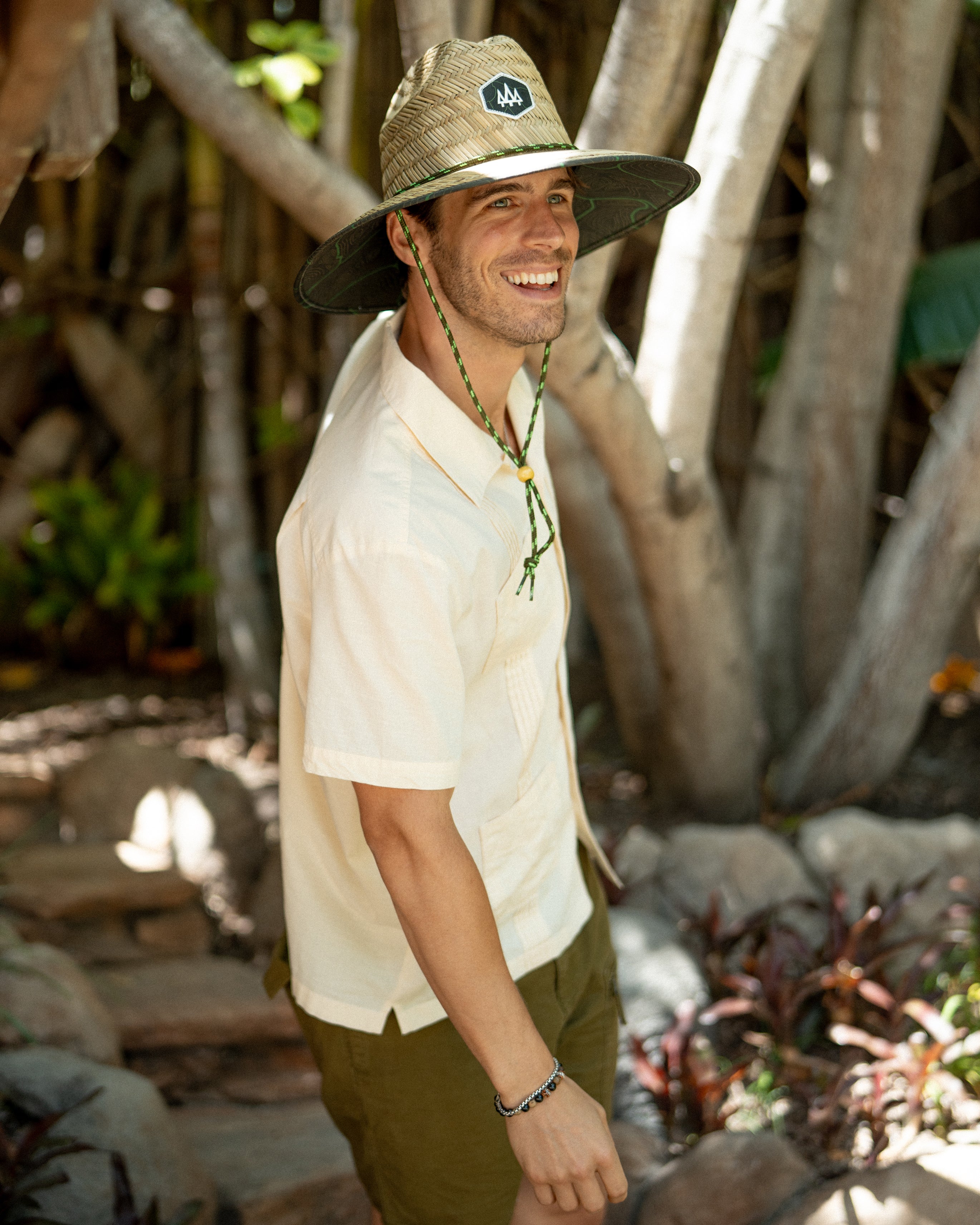 Hemlock male model smiling and wearing the UPF50+ Lifeguard Straw Hat Nomad Green print