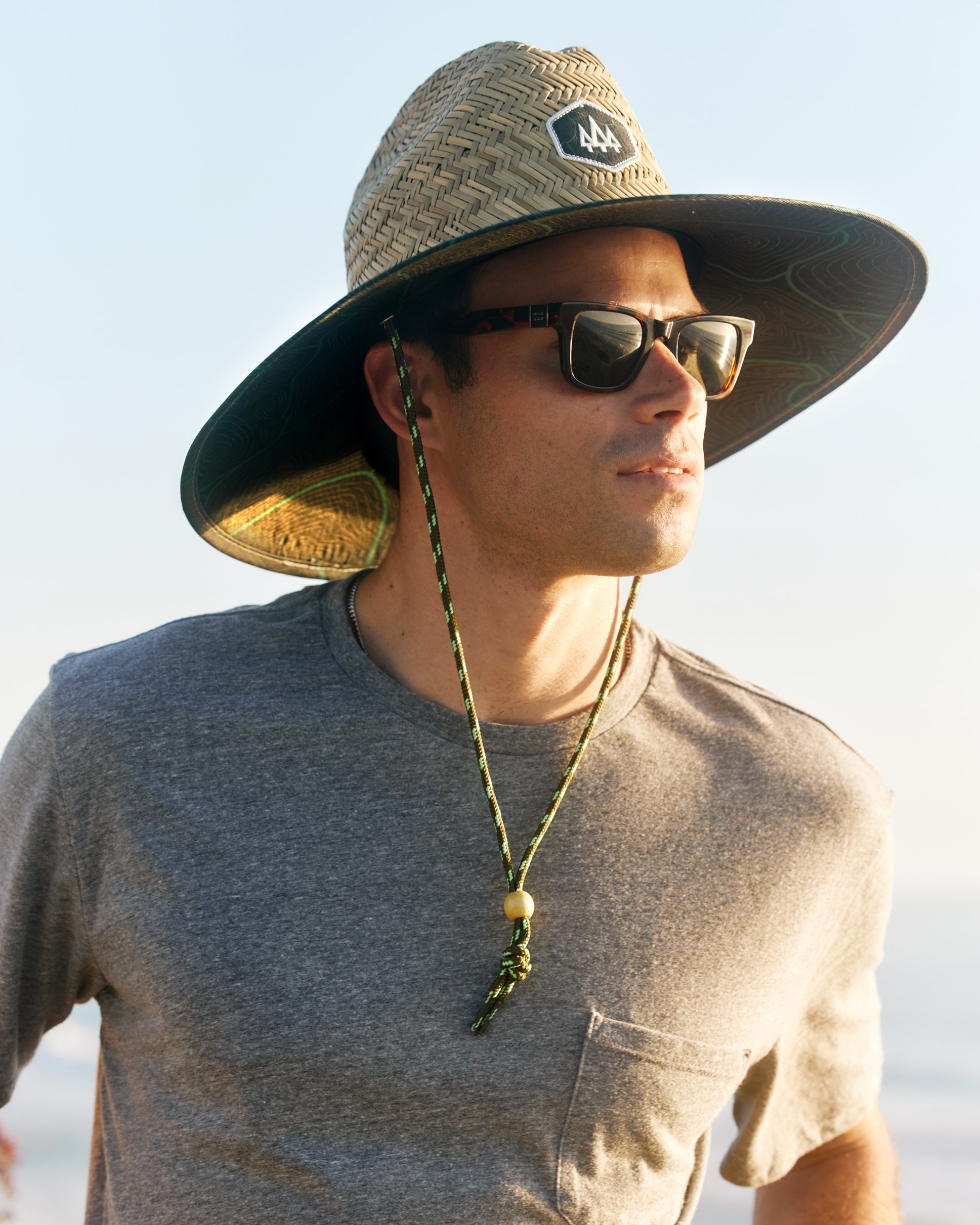 Hemlock male model close up wearing the UPF50+ Lifeguard Straw Hat Nomad Green print