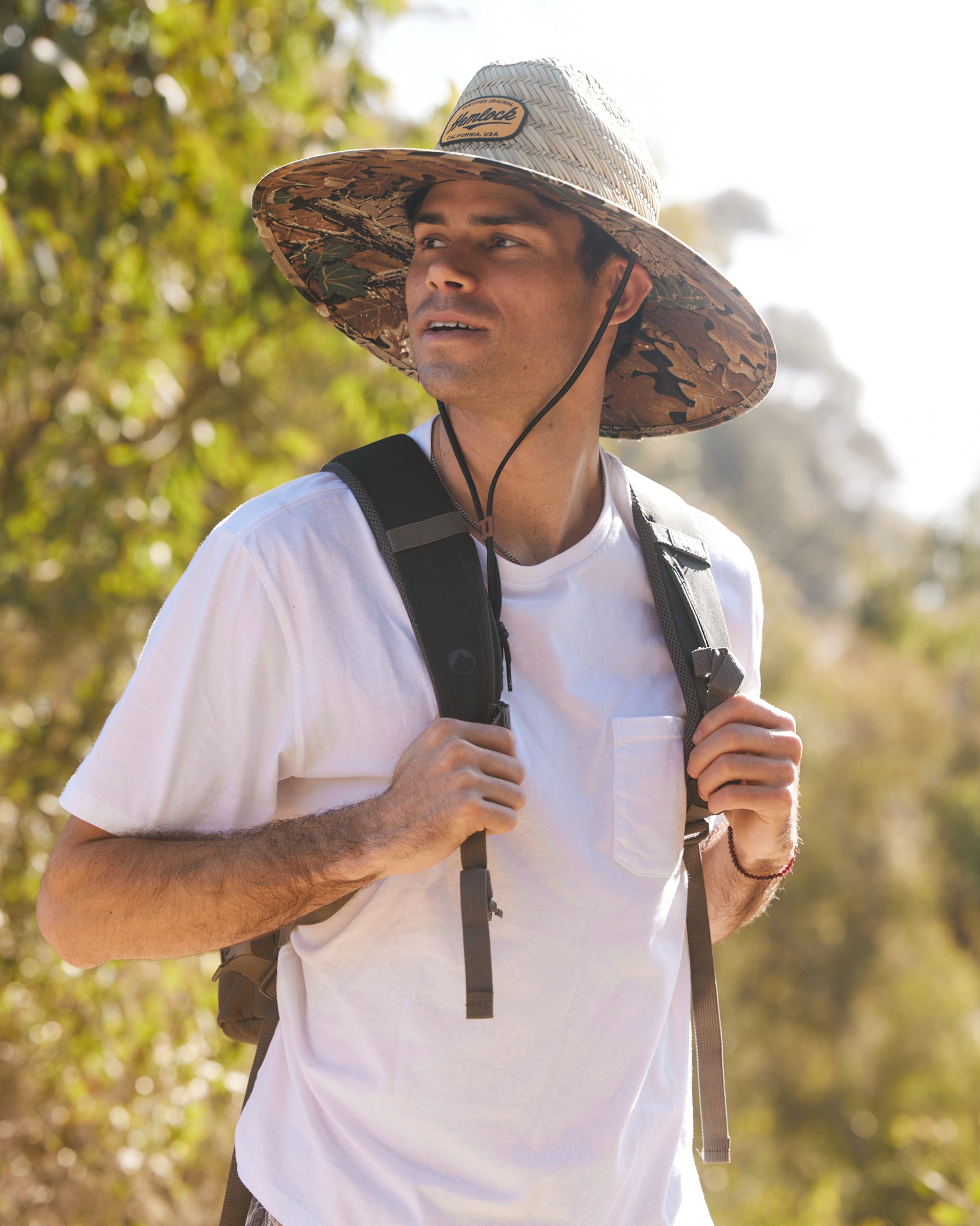 Hemlock male model wearing the UPF50+ Lifeguard Straw Hat Realtree® Advantage Camo print hiking