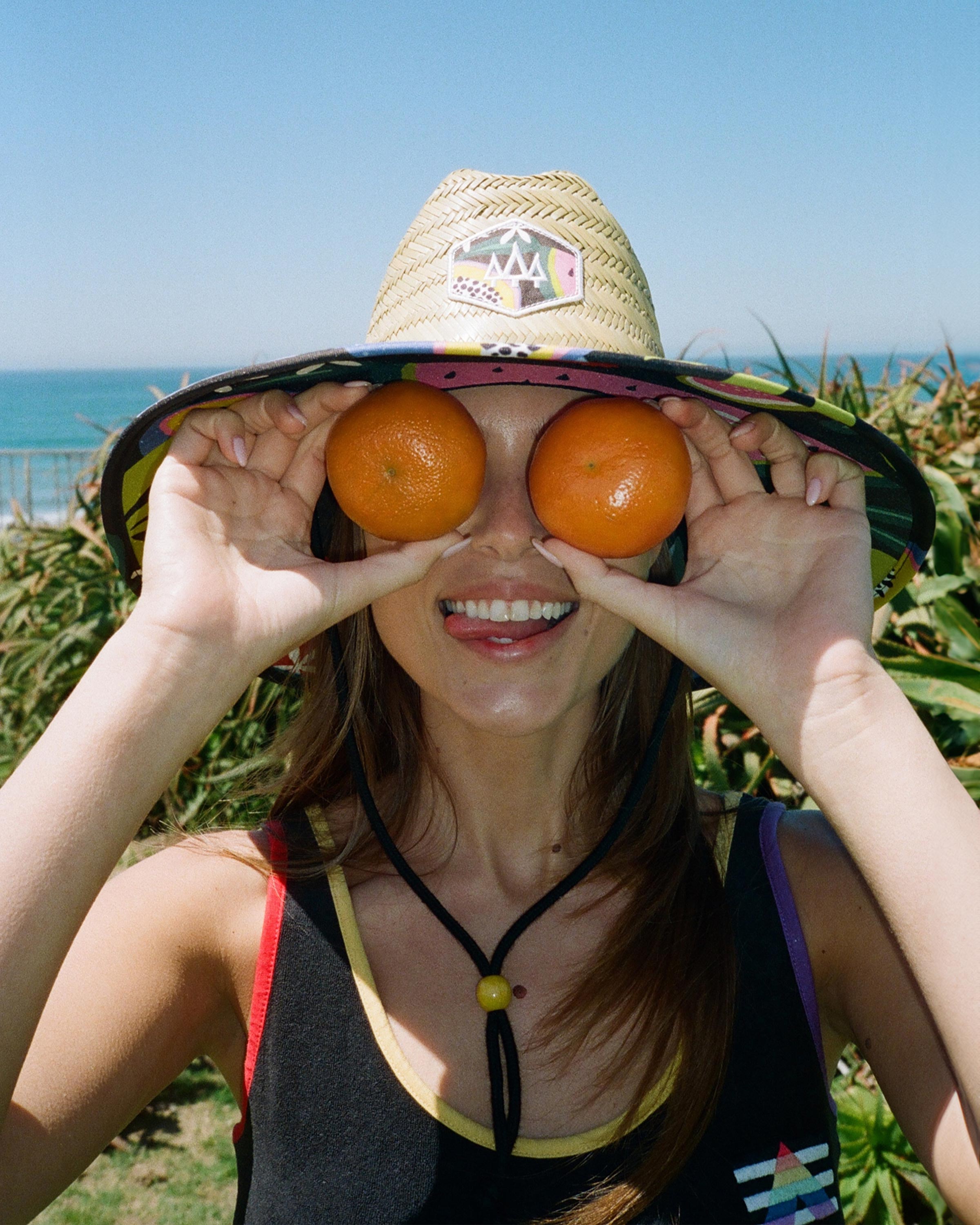 Hemlock female model wearing Blend straw lifeguard hat with Fruit pattern