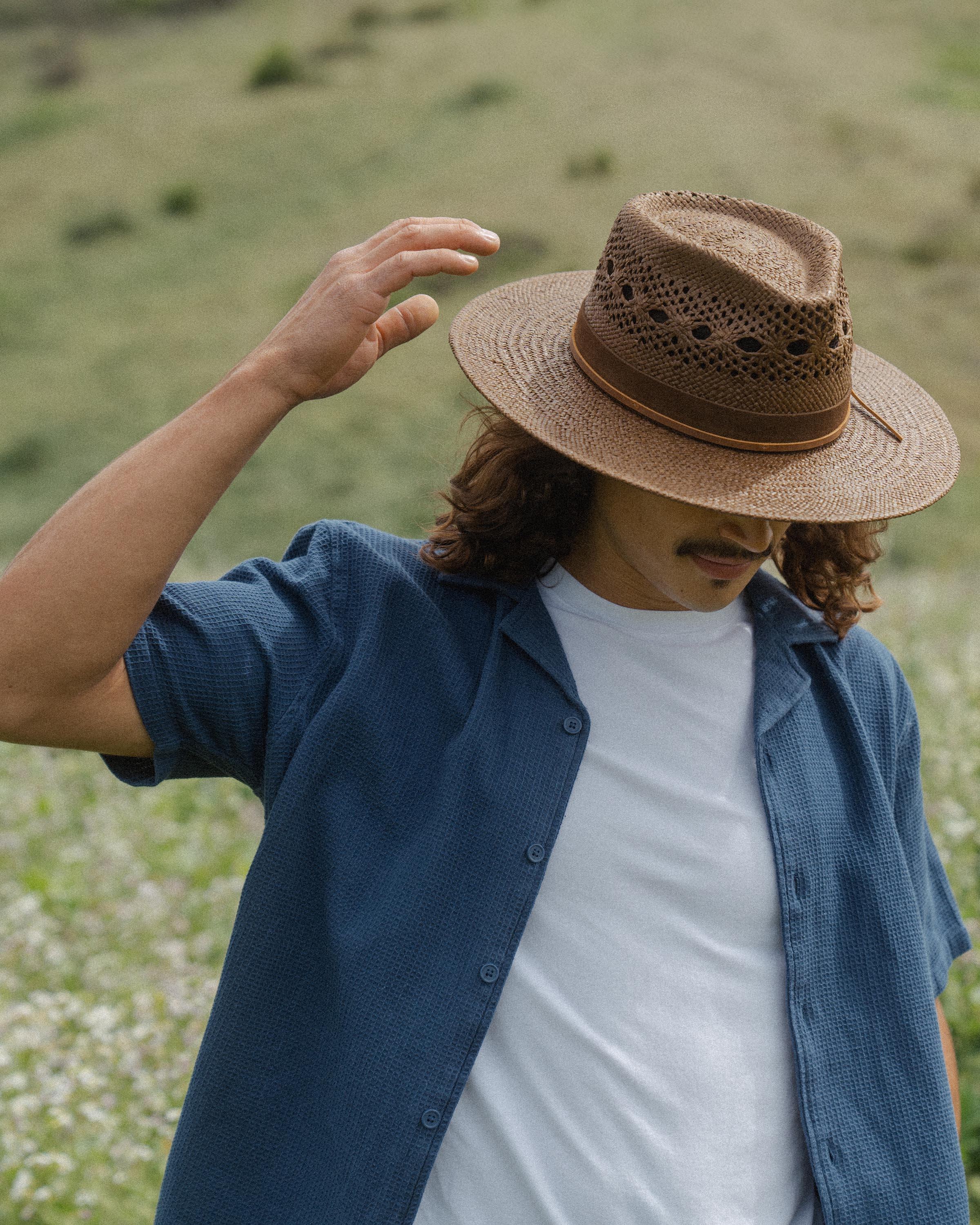 Hemlock male model looking down wearing Miller Straw Hat in Mocha